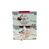 Deux savons à l’aker fassi Aza Natural empilés, dans leurs fourreaux de carton ondulé, l’un noué de raphia
