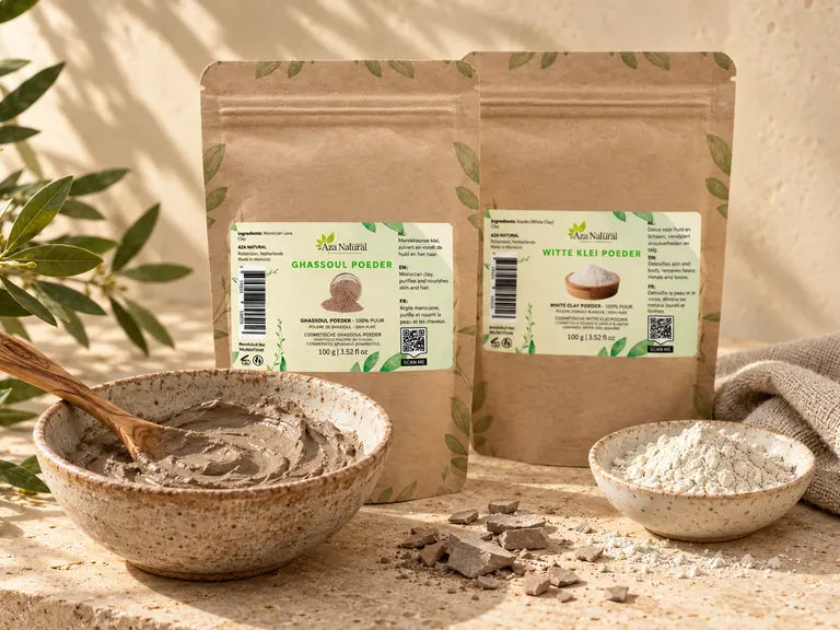 Zakjes Ghassoul poeder en Witte klei poeder van Aza Natural met een kom kleimasker, een houten lepel en een handdoek